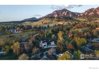 Stunning aerial view showcases a luxury home nestled in a lush, green landscape with beautiful mountain views at 2100 Kohler Dr, Boulder, CO 80305