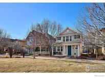 Charming two-story home with a well-manicured front yard and inviting porch on a beautiful sunny day at 2362 Xanthia Way, Denver, CO 80238