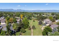 Expansive aerial view of property with lush landscaping and a backdrop of majestic mountains in the distance at 2549 Cowley Dr, Lafayette, CO 80026