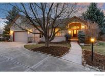 Charming stucco home featuring a well-manicured front yard, spacious driveway, and attached garage at 2549 Cowley Dr, Lafayette, CO 80026