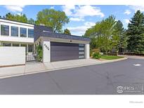 Bright exterior of home featuring attached garage, manicured landscaping, and white painted brick at 4804 Briar Ridge Ct, Boulder, CO 80301