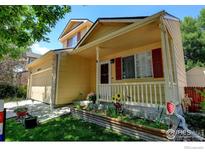 Inviting two-story home with a charming porch and well-maintained front yard and two-car garage at 5241 E 128Th Way, Thornton, CO 80241