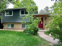 Charming two-story home featuring a gray-and-brick facade with a vibrant red front door and well-maintained landscaping at 5355 Kewanee Dr, Boulder, CO 80303