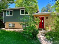 Charming home with a red front door, brick facade, and lush greenery, creating a welcoming curb appeal at 5355 Kewanee Dr, Boulder, CO 80303