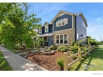 Charming two-story home featuring stone accents, a landscaped yard with a fire pit, and a welcoming entrance at 633 Deerwood Dr, Longmont, CO 80504