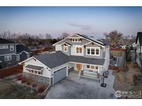 Beautiful two-story home with a basketball hoop, porch seating, and solar panels at 785 Delechant Dr, Erie, CO 80516