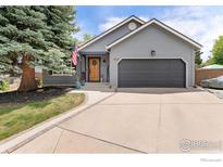 Charming home featuring a gray exterior, a large front yard tree, and a welcoming two-car garage at 8391 Sunnyside Pl, Highlands Ranch, CO 80126