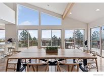 Bright dining area with large windows offering scenic views and a large table for gatherings at 8654 Thunderhead Dr, Boulder, CO 80302