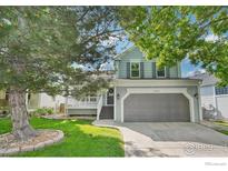 Charming two-story home with a well-manicured lawn and a two car garage at 14418 W Yale Pl, Lakewood, CO 80228