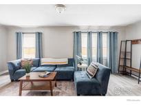 Comfortable living room featuring a plush blue couch and a wooden coffee table with stylish decor at 2565 Pierce St, Lakewood, CO 80214
