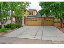 Charming two-story home featuring brick accents, a two-car garage, and mature trees in the front yard at 2631 E 136Th Pl, Thornton, CO 80602
