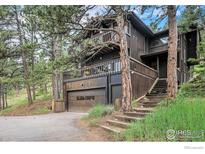 Stunning multi-story home featuring wood siding, a garage, and multiple decks with natural surroundings at 335 Wild Horse Cir, Boulder, CO 80304