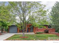 Charming brick home with a covered front porch and mature landscaping at 3445 Martin Dr, Boulder, CO 80305
