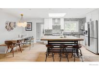 Modern kitchen featuring stainless steel appliances, a large island, and a dining area at 3445 Martin Dr, Boulder, CO 80305