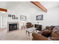 Comfortable living room featuring a fireplace, plush seating, and a vaulted ceiling with exposed beams at 5520 Stonewall Pl # 31, Boulder, CO 80303