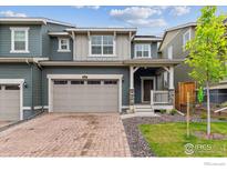 Charming two-story home boasts a brick driveway, two-car garage, and inviting front porch at 645 Flintwood Pl, Lafayette, CO 80026