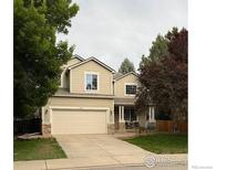 Charming two-story home with a two car garage and a well-maintained lawn and mature trees at 804 Nelson Park Ln, Longmont, CO 80503