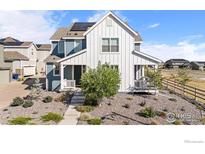Charming two-story home with stylish curb appeal, a covered porch, and solar panels at 8353 Bijou Creek Ave, Littleton, CO 80125