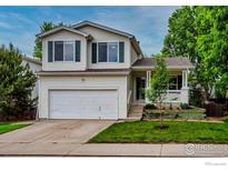 Charming two-story home featuring a two-car garage, covered front porch, and landscaped yard at 1309 Red Mountain Dr, Longmont, CO 80504