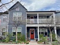 Two-story home with a porch that features white railings and a red front door at 1400 Lee Hill Dr # 1, Boulder, CO 80304