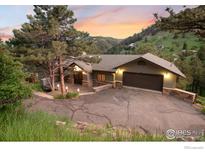 Stunning exterior view of a home with a beautiful driveway, lush trees, and a two-car garage at 142 Meadowlook Way, Boulder, CO 80304