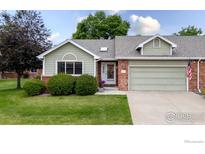 Charming single-story home with manicured lawn, brick accents, and an attached garage in a desirable neighborhood at 1515 Tulip Ct, Longmont, CO 80501