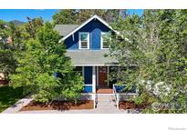 Charming blue two-story home with a welcoming front porch and mature trees at 1519 16Th St, Boulder, CO 80302