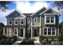 Charming gray two-story townhomes with well-manicured landscaping under a clear blue sky at 165 Washington St, Erie, CO 80516