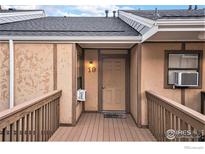 Inviting front entrance featuring a cozy porch, beige siding, and clearly marked unit number at 225 E 8Th Ave # C-19, Longmont, CO 80504
