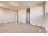 Bright bedroom features neutral walls, plush carpeting and multiple windows providing natural light at 2718 Crystal Springs Ln, Longmont, CO 80503