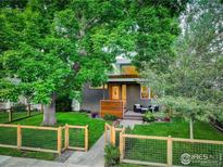 Charming home featuring mature landscaping, a fenced yard, and a welcoming front porch seating area at 2750 7Th St, Boulder, CO 80304