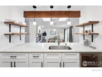 Bright kitchen featuring white cabinets, marble countertops, open shelving, and pendant lighting at 3255 34Th St # 42, Boulder, CO 80301