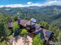 Stunning mountain home with a telescope dome and solar panels, nestled among lush greenery and offering breathtaking mountain views at 409 Wild Horse Cir, Boulder, CO 80304