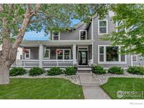 Charming two-story home boasts a welcoming porch, manicured lawn, and professional landscaping at 5111 Mt St Vrain Ave, Frederick, CO 80504