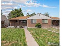Charming brick home with a well-maintained lawn and pathway leading to the entrance at 547 S Eliot St, Denver, CO 80219