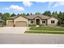 Charming single-story home with a three-car garage, landscaped yard, and stone accents on the facade at 10882 Legacy Ridge Way, Westminster, CO 80031
