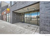 Modern building exterior featuring brick facade and well-lit entryway with large glass windows at 1616 S Broadway # 304, Denver, CO 80210
