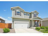 Charming two-story home with a two-car garage, landscaped yard, covered porch, and neutral color palette at 2509 Alto St, Fort Lupton, CO 80621