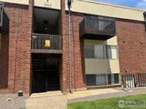 Apartment building with brick facade and private balconies, creating an inviting curb appeal at 3623 S Sheridan Blvd # 11, Lakewood, CO 80235