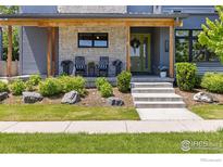 Charming covered front porch with stone accents, rocking chairs, and lush landscaping at 3681 Paonia St, Boulder, CO 80301