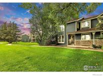 Inviting two-story townhome with a stone facade and lush front lawn at 3807 Paseo Del Prado, Boulder, CO 80301