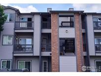 Condo with private balcony, gray siding, and red brick at 50 19Th Ave, Longmont, CO 80501
