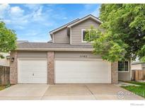 Charming home featuring a three-car garage, brick accents, and neutral-colored siding at 11740 Ivy St, Thornton, CO 80233