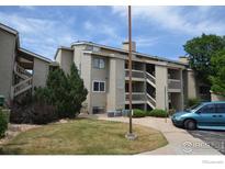 Exterior view of a condo building with well-maintained landscaping and a blue minivan parked out front at 30 S Boulder Cir # 3018, Boulder, CO 80303