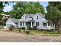 Charming two-story home featuring light blue siding, a covered porch, and a well-manicured front yard with beautiful landscaping at 3561 4Th St, Boulder, CO 80304