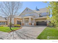 Charming two-story home with stone accents, inviting front porch, and well-manicured lawn at 4119 Riley Dr, Longmont, CO 80503