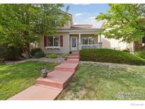 Charming two-story home with red shutters, a covered porch, and a well-manicured front yard at 4725 Spyglass Dr, Broomfield, CO 80023