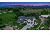 Expansive home featuring a large lawn, mountain views, and mature trees at 7215 Hygiene Rd, Longmont, CO 80503