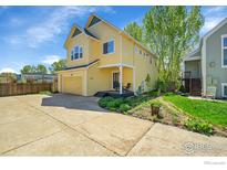 Charming two-story home with a well-maintained lawn, driveway and attached garage in a suburban neighborhood at 740 Boxwood Ln, Longmont, CO 80503