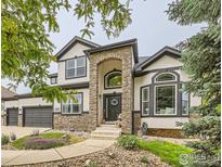 Charming two-story home showcasing a stone archway entrance and well-maintained landscaping at 8839 Shetland Dr, Frederick, CO 80504